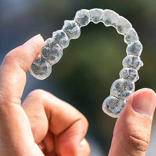 Orthodontist holding invisalign aligner in hand