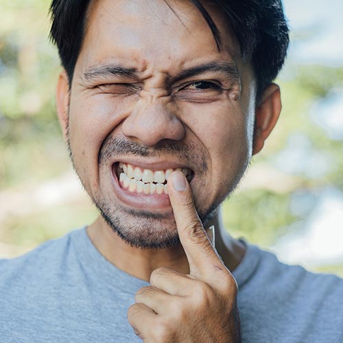 "man with tooth pain is recommended for a root canal in Mississauga